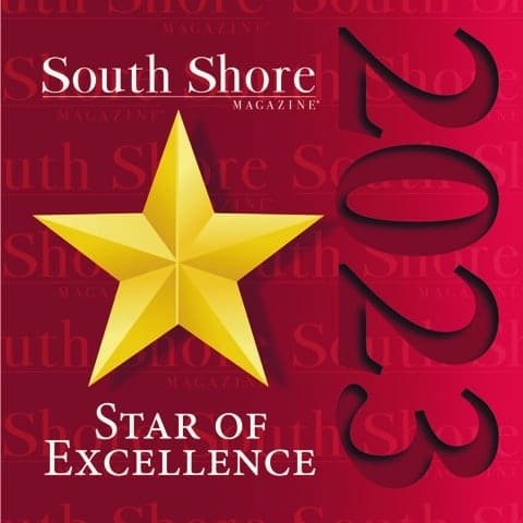 A gold star with the text South Shore Magazine 2023 Star of Excellence on a red background with subtle repeating text, highlighting top memory care Massachusetts and Norwell nursing home recognition.