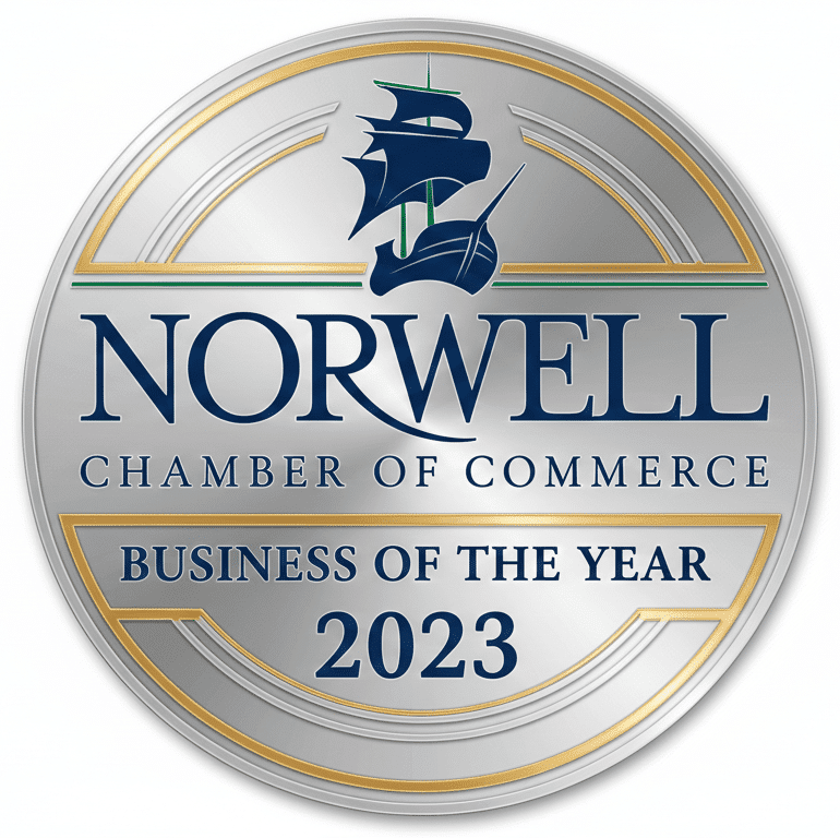 A silver and gold circular badge reads “Norwell Chamber of Commerce, Business of the Year 2023,” with two stylized sailing ships above the text.