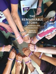 A diverse group of people join their hands in a circle, each wearing a purple wristband. Featured in South Shore Magazine, the text overlay reads, THE REMARKABLE STORY: LIFE, PURPOSE AND POSSIBILITIES. Written by Robin Carney.
